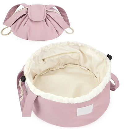 Dusty rose barrel makeup bag with drawstring closure, handles, and cream-lined interior