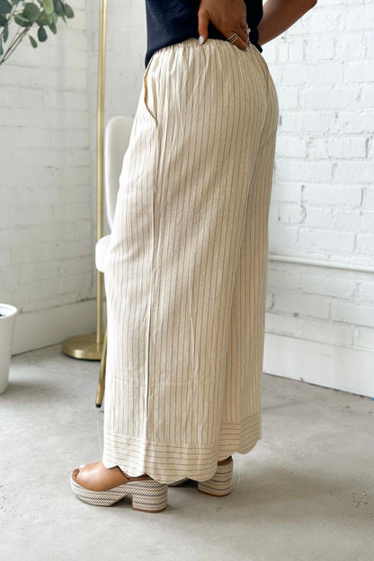 Oatmeal wide-leg pants with scalloped hem and vertical pinstripes, side view