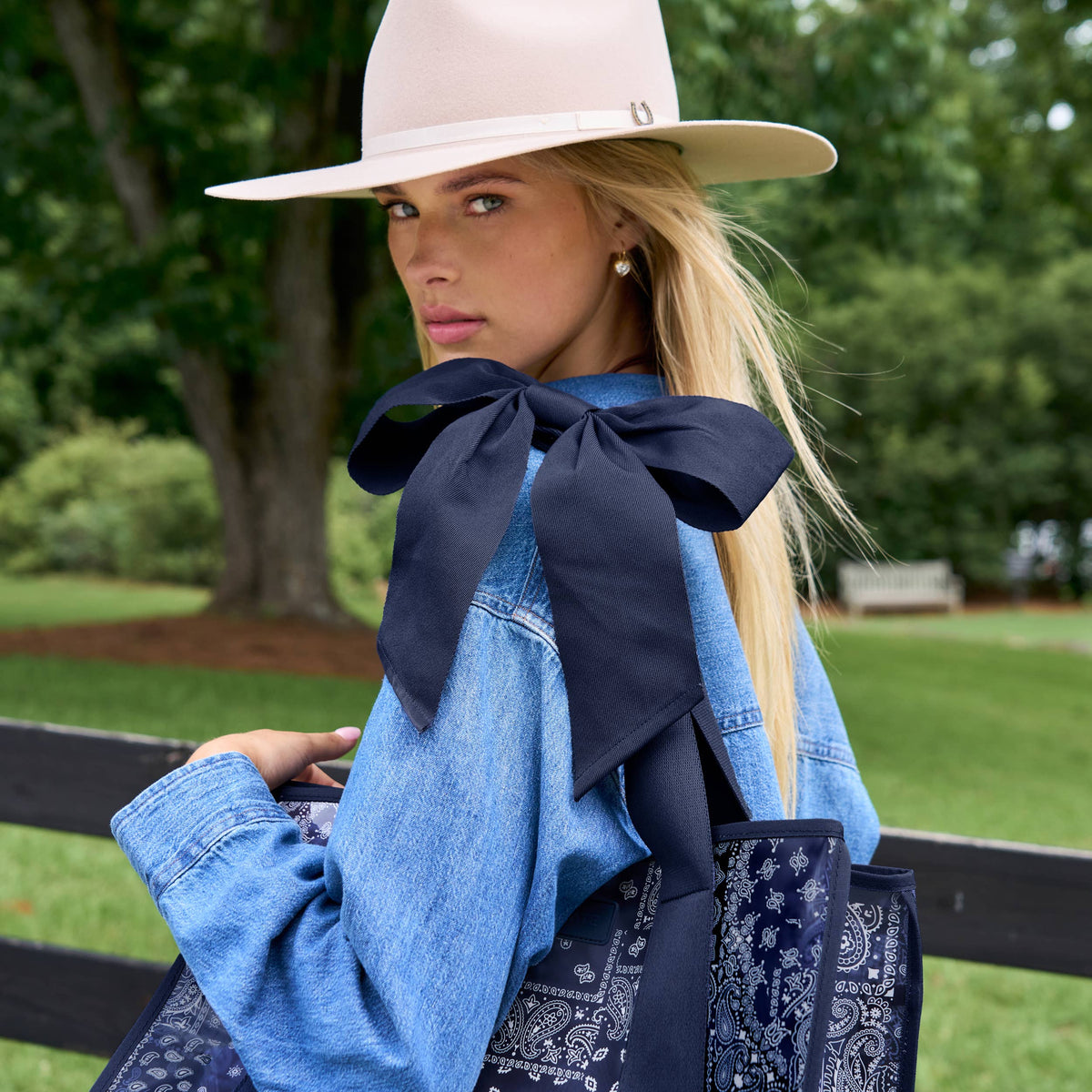 Navy tote bag with paisley bandana pattern, oversized bow, and top handles.