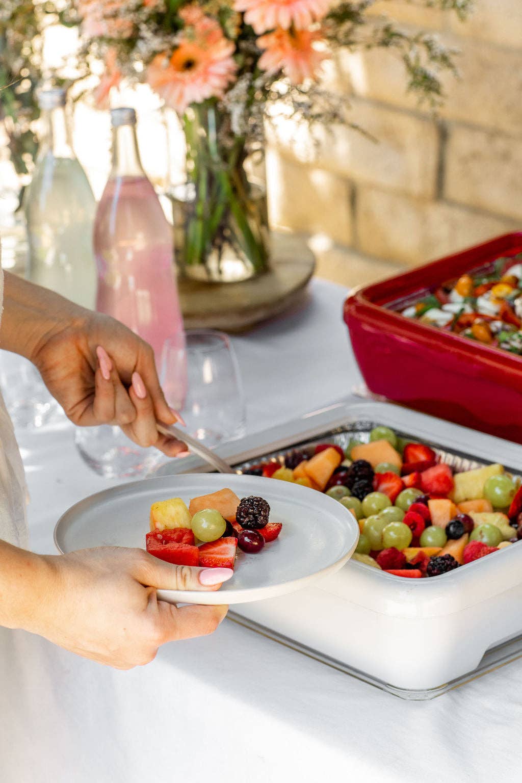 Serving salad from a white insulated foil pan carrier with red lid