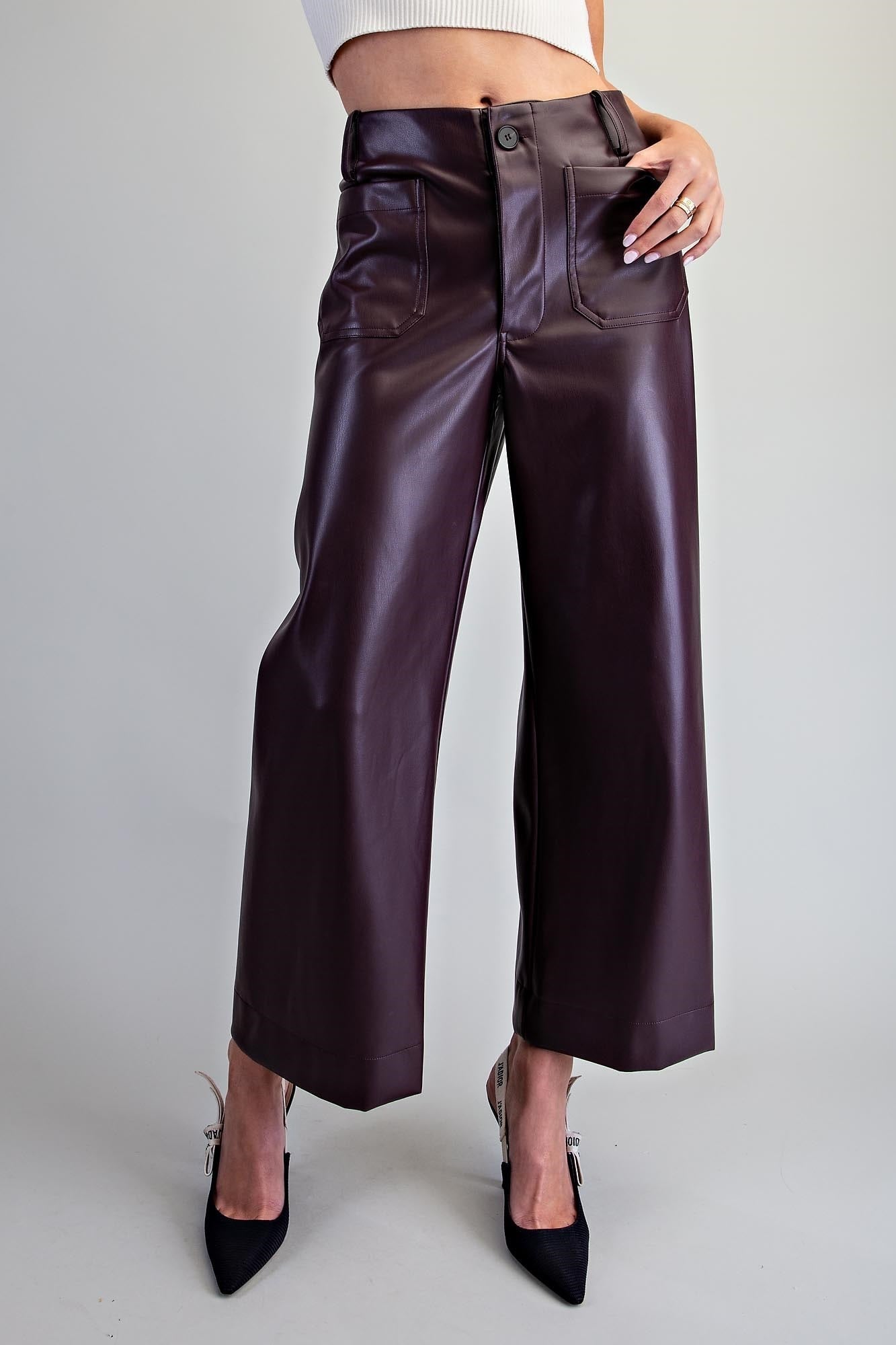 Black pleather pants with roomy patch pockets and a smooth finish