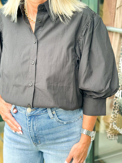 Black top with gathered puff sleeves and buttons