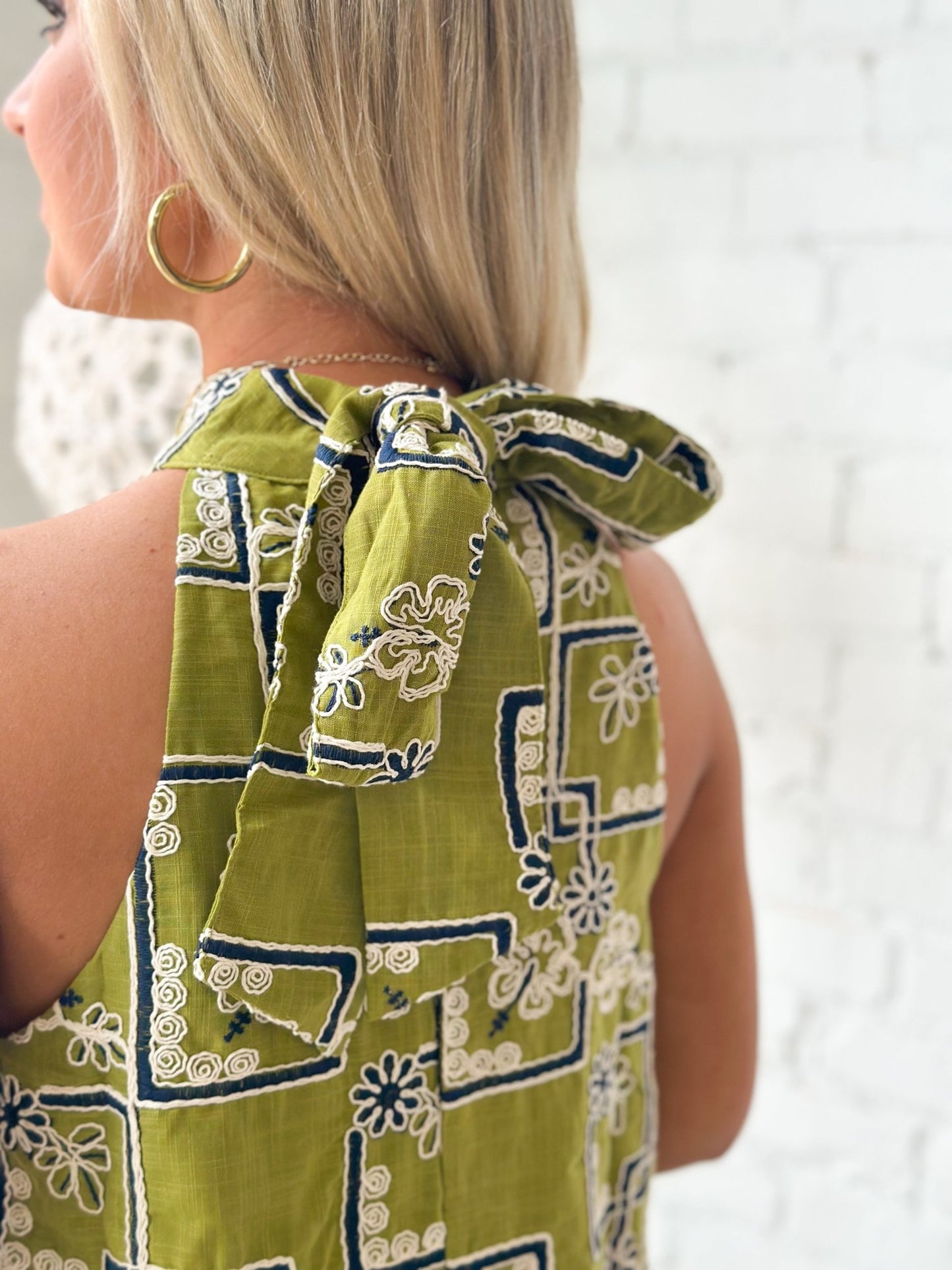 Ruffle trim on an embroidered olive dress