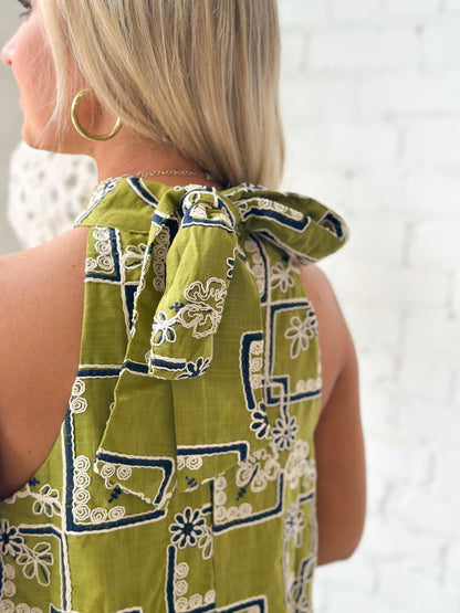 Ruffle trim on an embroidered olive dress