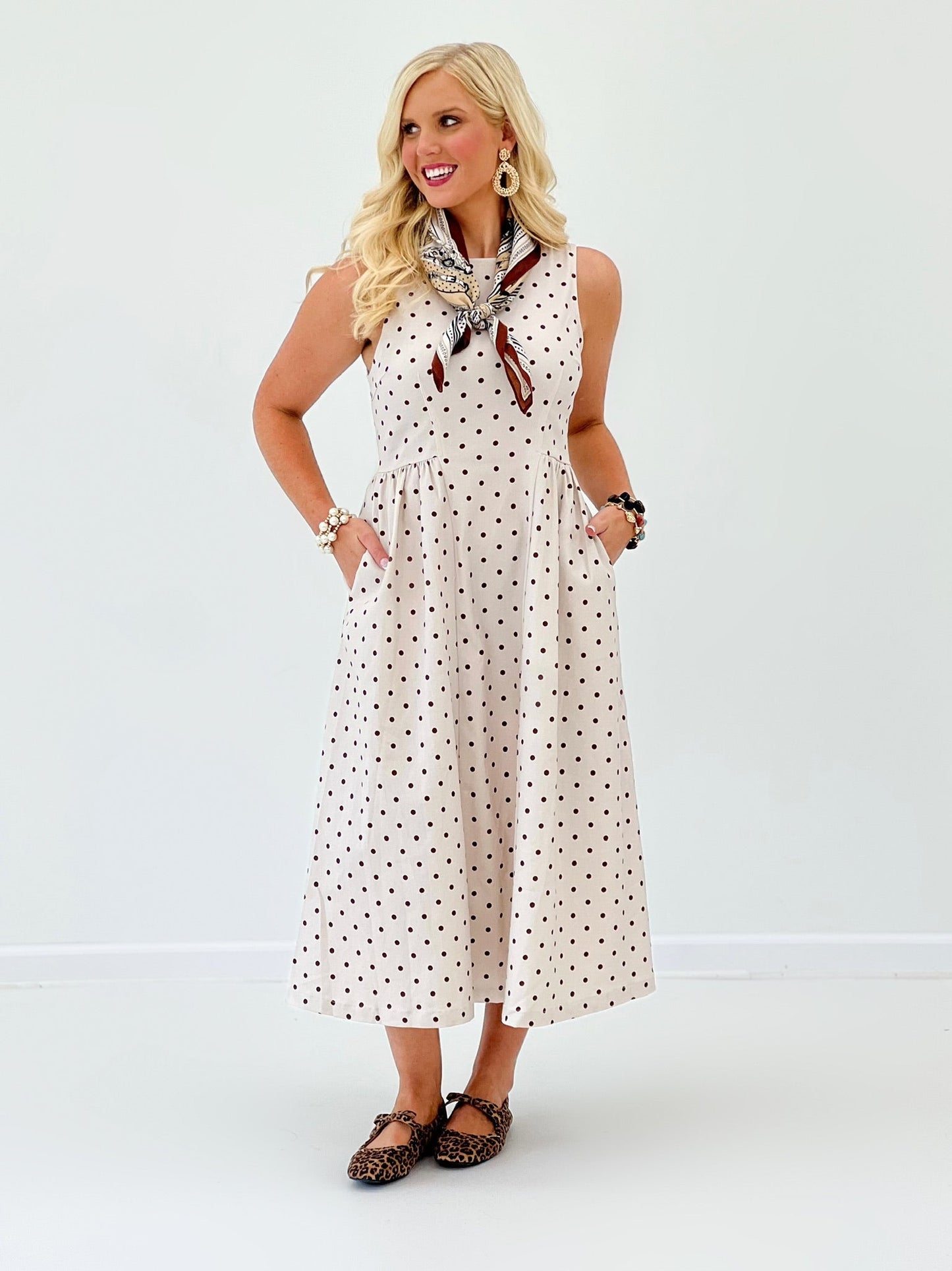 Pleat detail on an ecru polka dot sleeveless dress