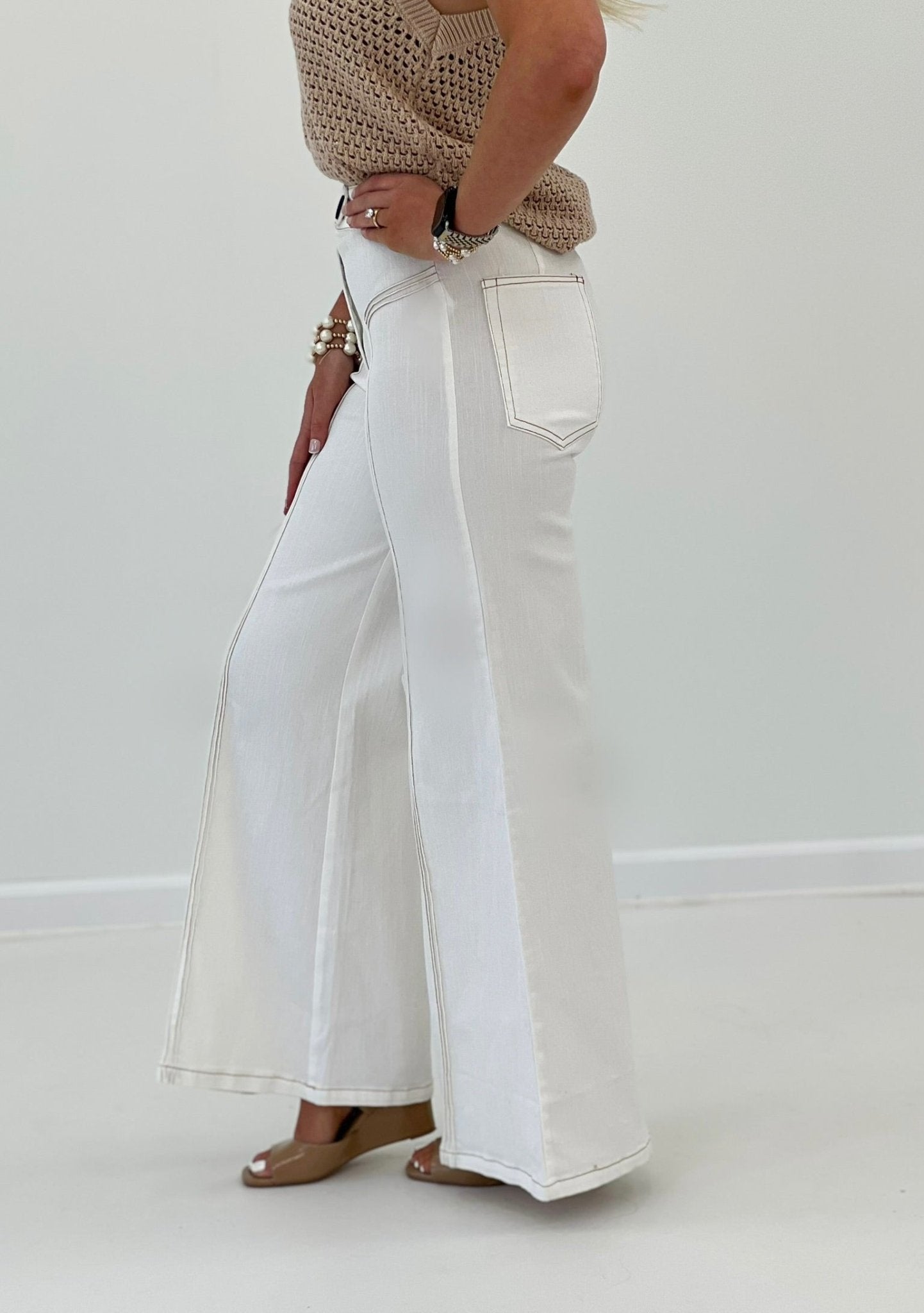 Cream flared pants with dark contrast stitch detail