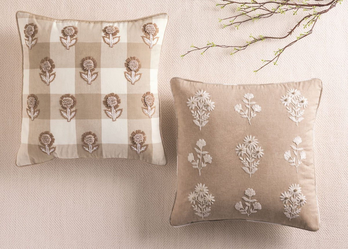 White embroidered botanicals on a beige throw pillow
