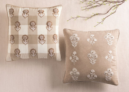 White embroidered botanicals on a beige throw pillow