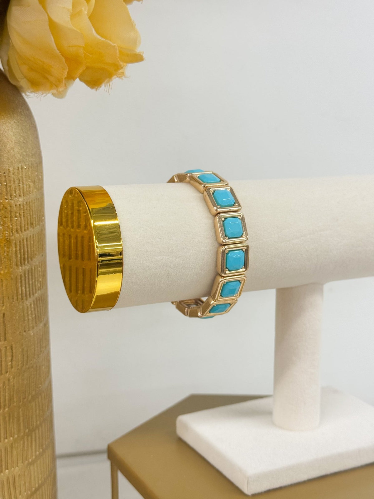 Square stones set in gold-tone frames on a bracelet