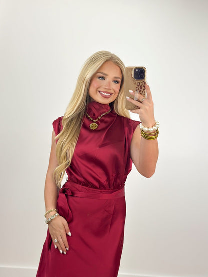 Draped cowl neckline on a burgundy sleeveless dress