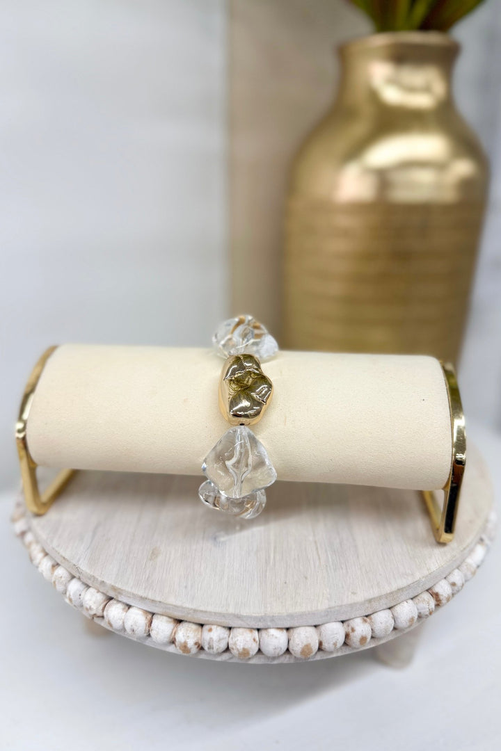 Gold bracelet with clear ice-toned beads and charms