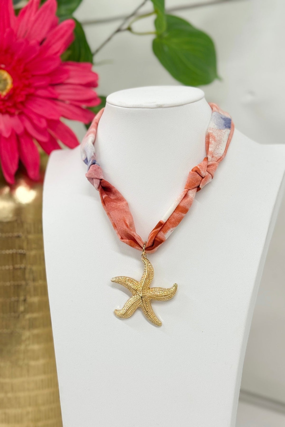 Gold necklace with a pink starfish pendant
