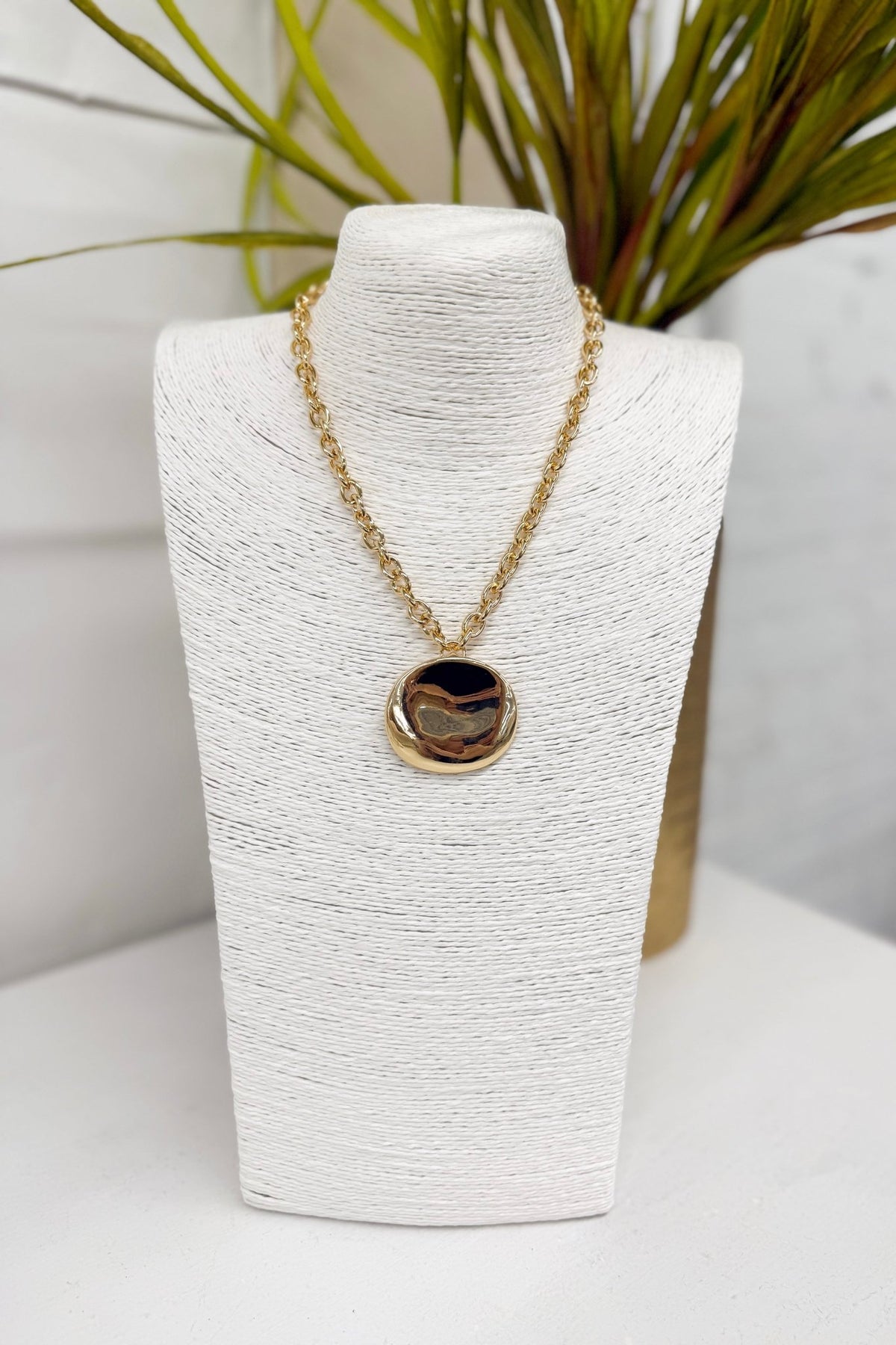 Gold disc pendant on a chain necklace