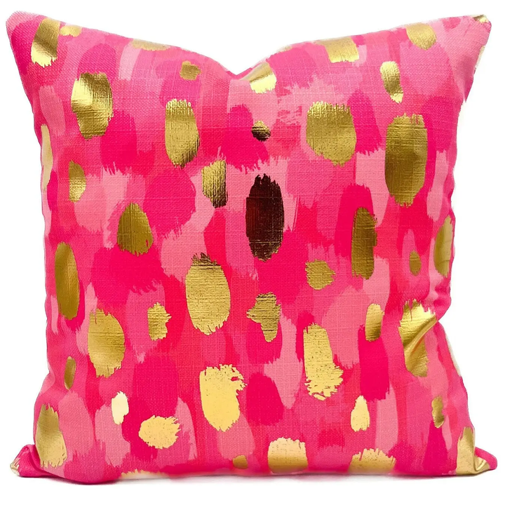 Throw pillow with fluorescent pink paint daubs and gold foil accents