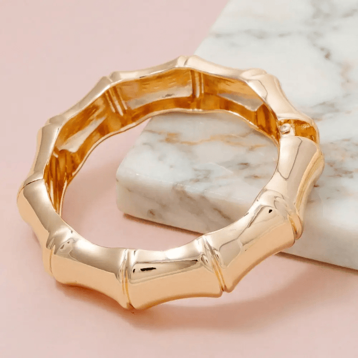 Gold hinged bangle with a bamboo texture