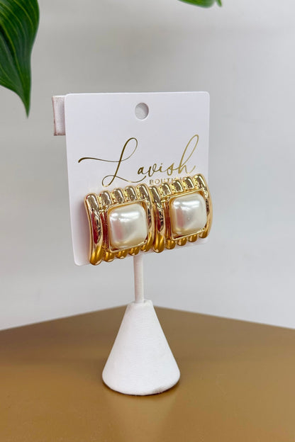 Square gold frames centered on round pearls