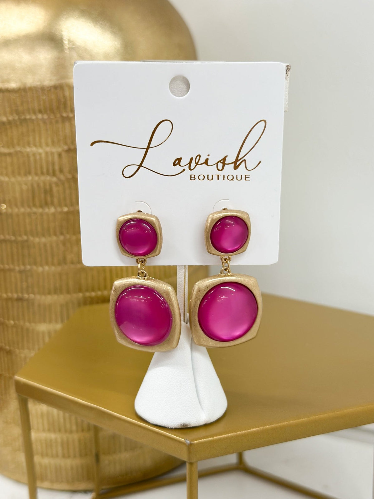 Bright pink stones set in polished gold earrings