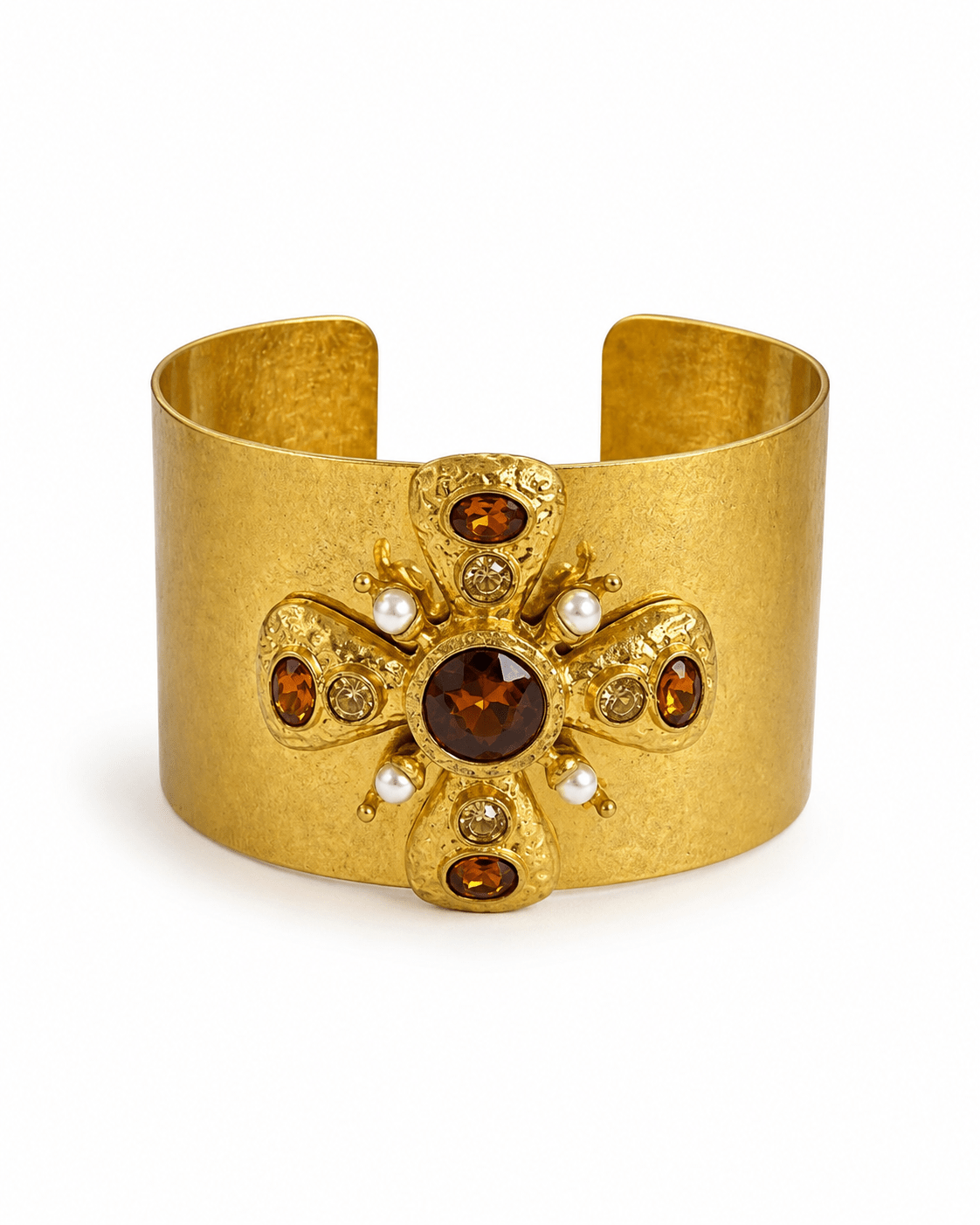 Wide gold cuff centered on an ornate cross