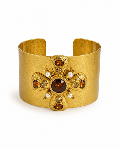 Wide gold cuff centered on an ornate cross