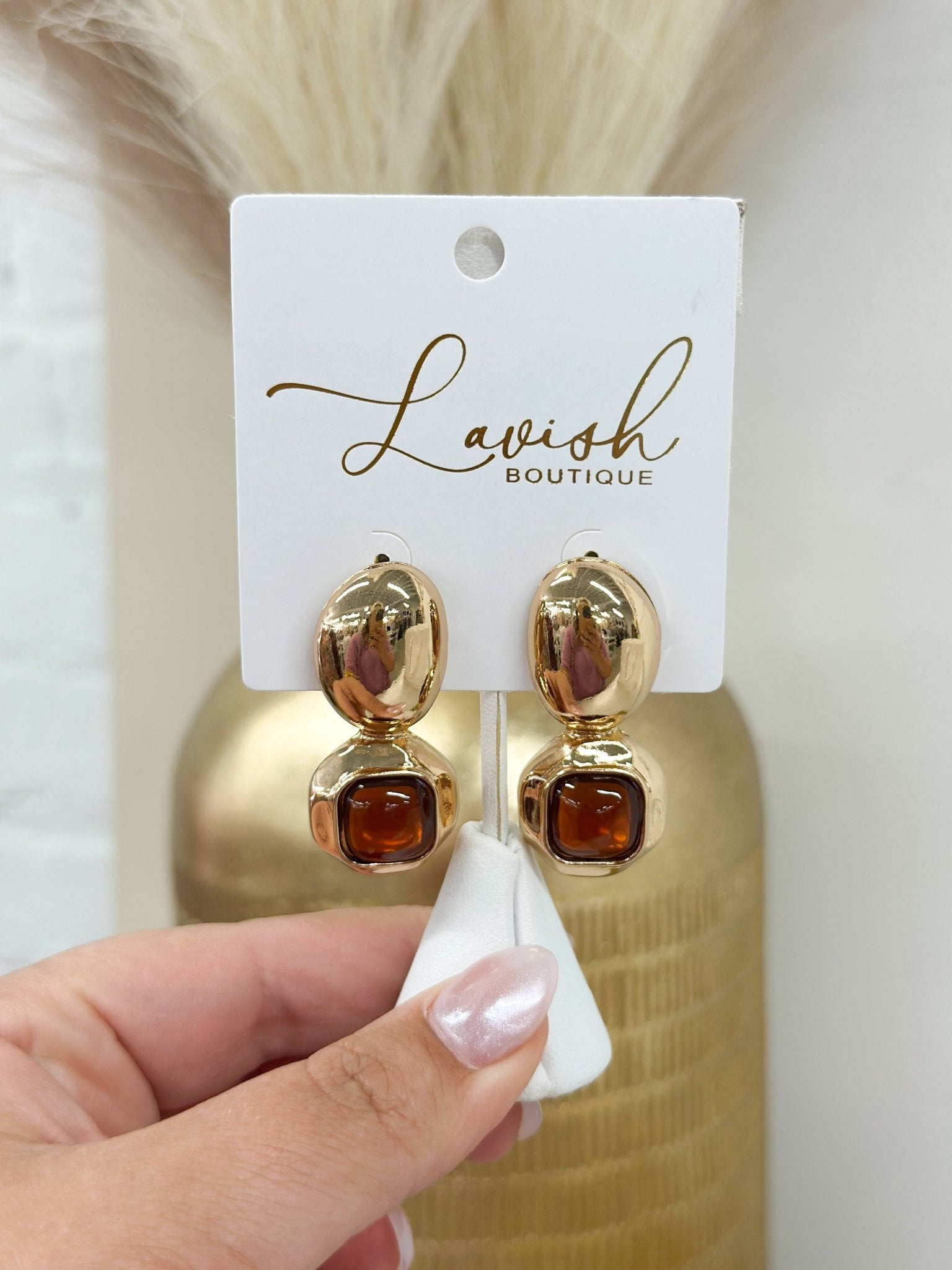 Earrings pairing a square dome stone with an oval drop