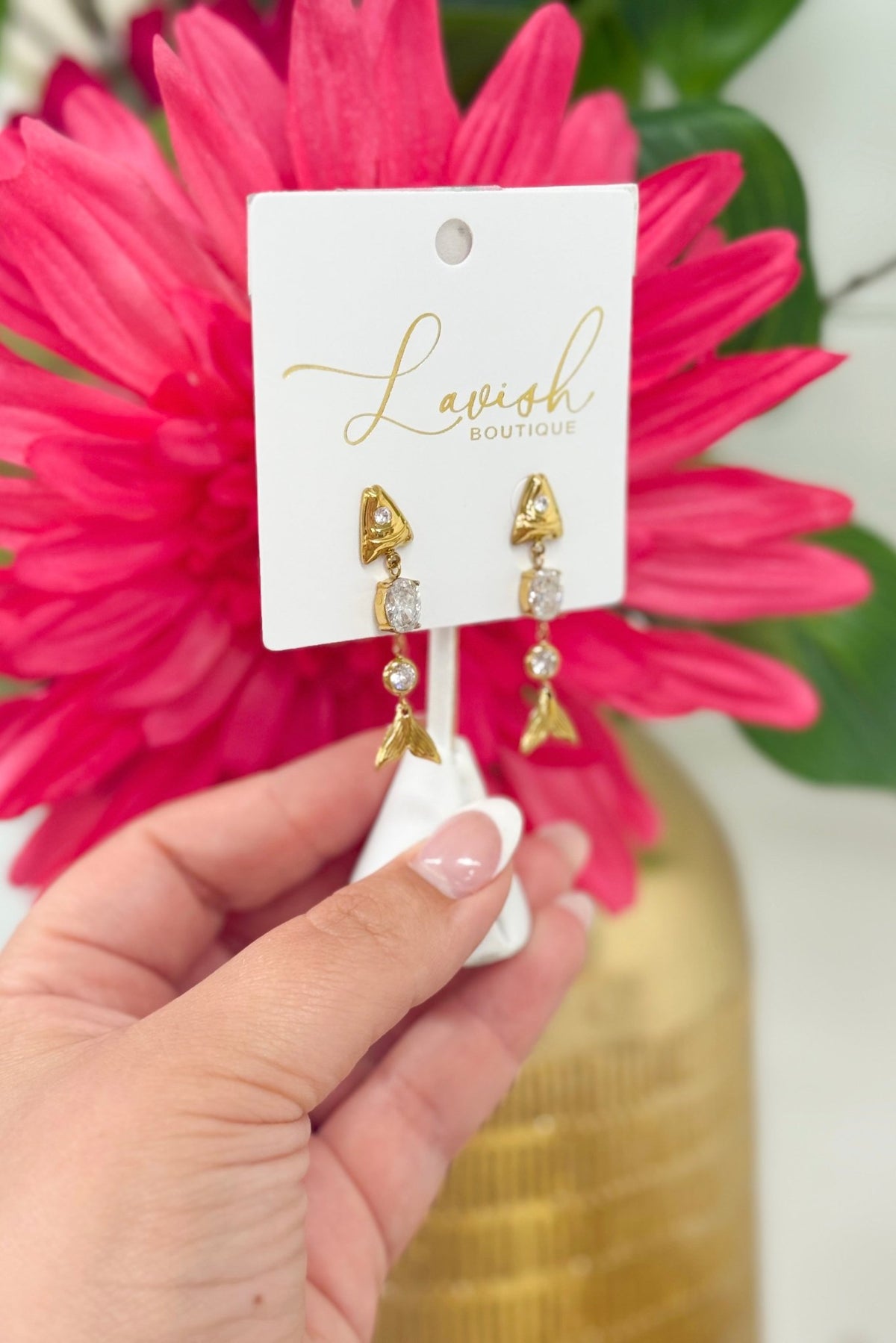 Gold earrings with a skeletal fish design