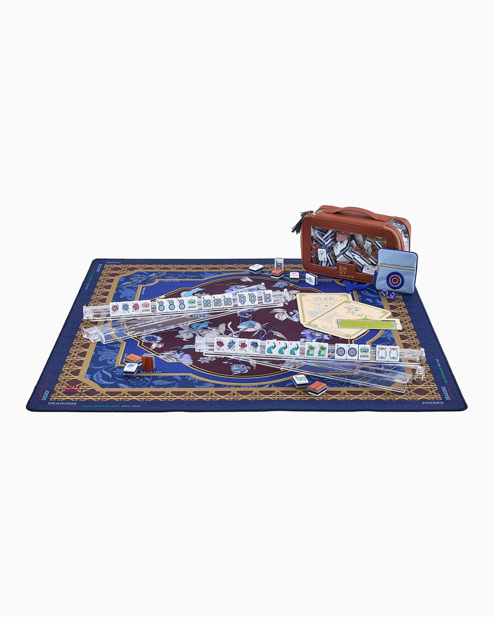 Mahjong play mat with navy blue floral artwork and gold geometric border, flat with tube.