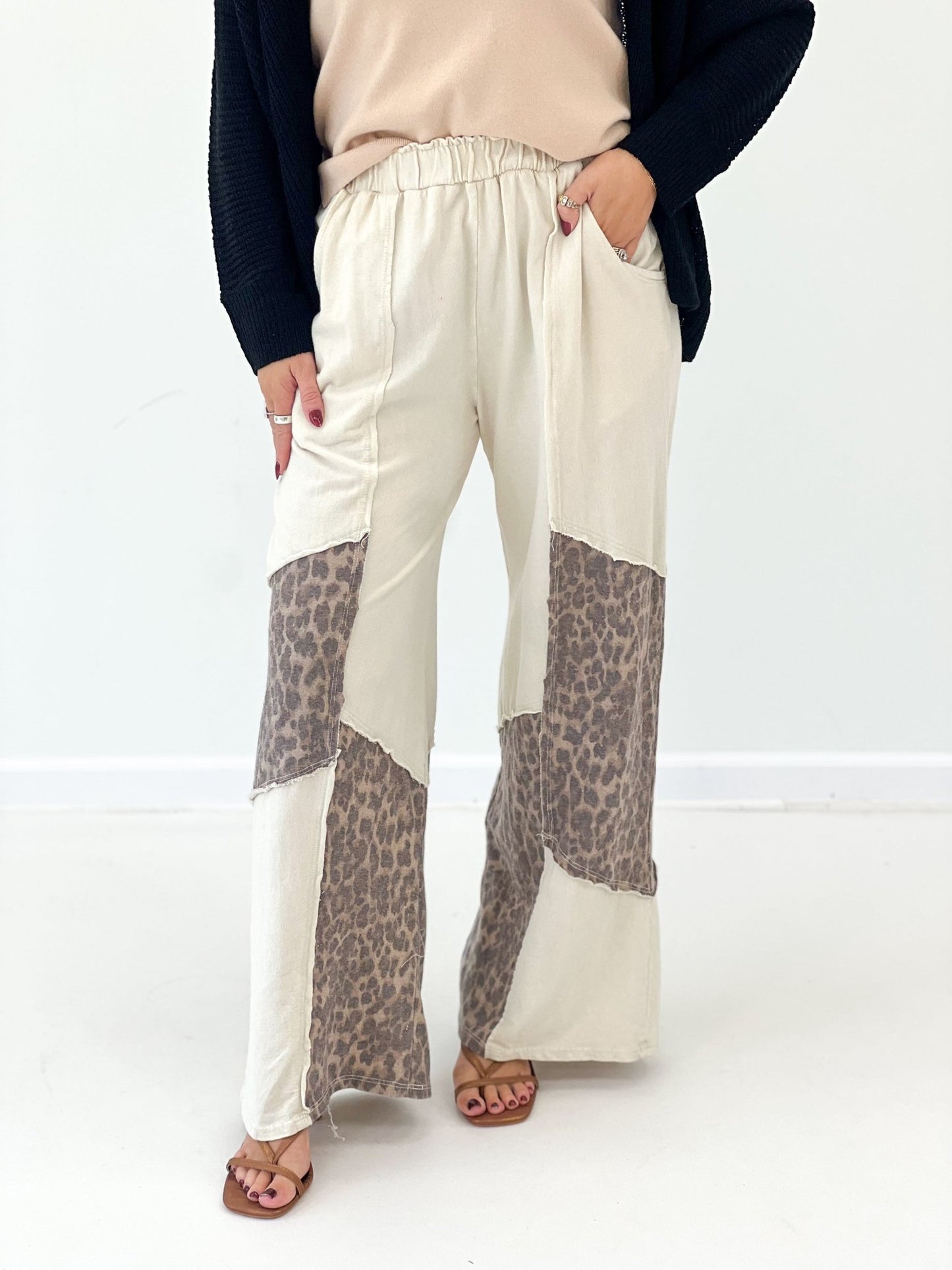 Cream wide-leg pants with leopard print patch at hem, elastic waist and roomy fit