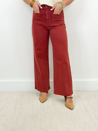 Deep burgundy jeans with a full wide leg and patch pockets