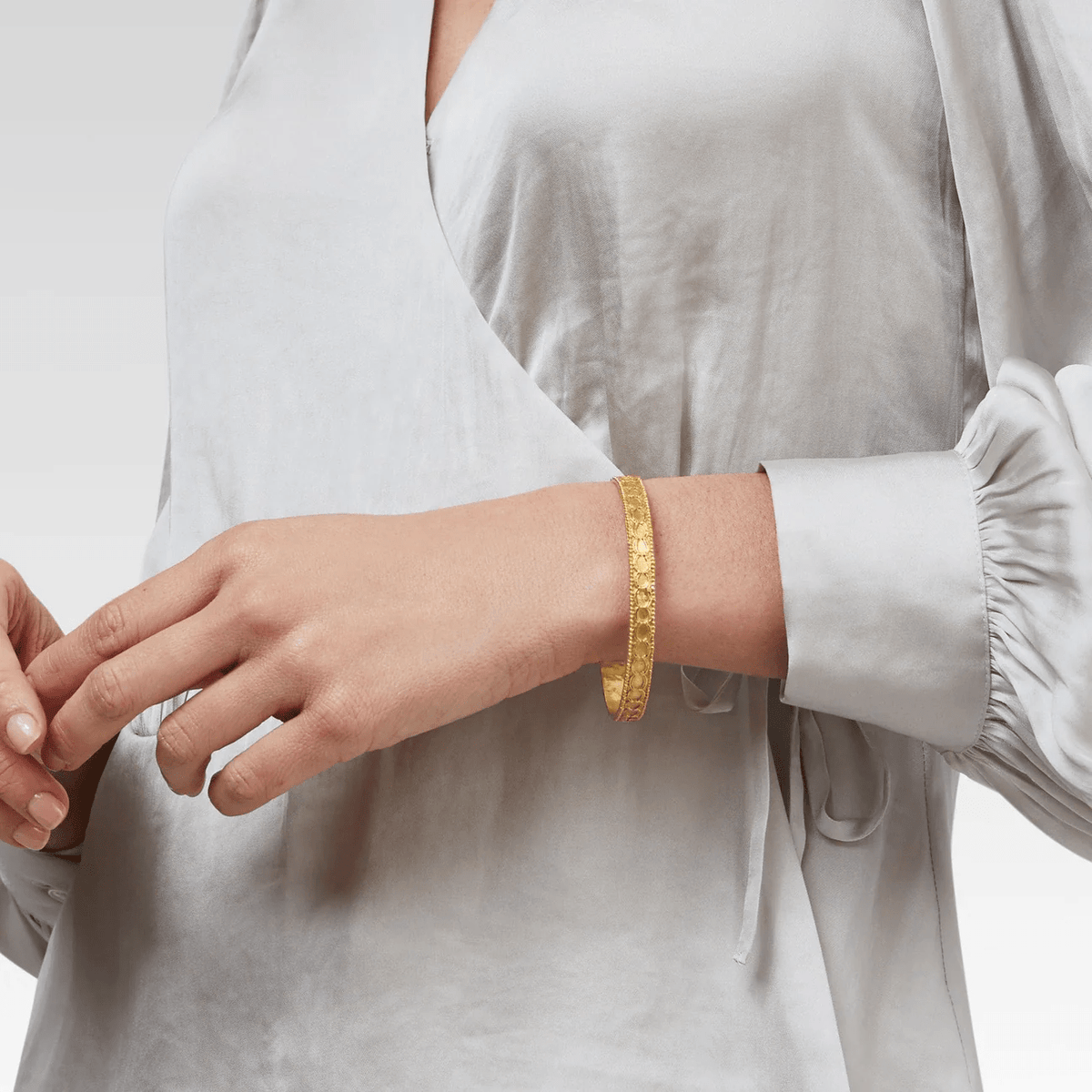 Gold bangle bracelet with a sculpted surface