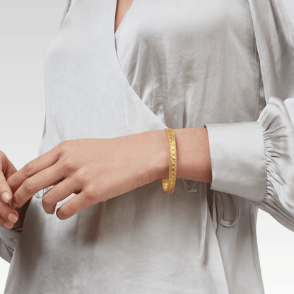 Gold bangle bracelet with a sculpted surface