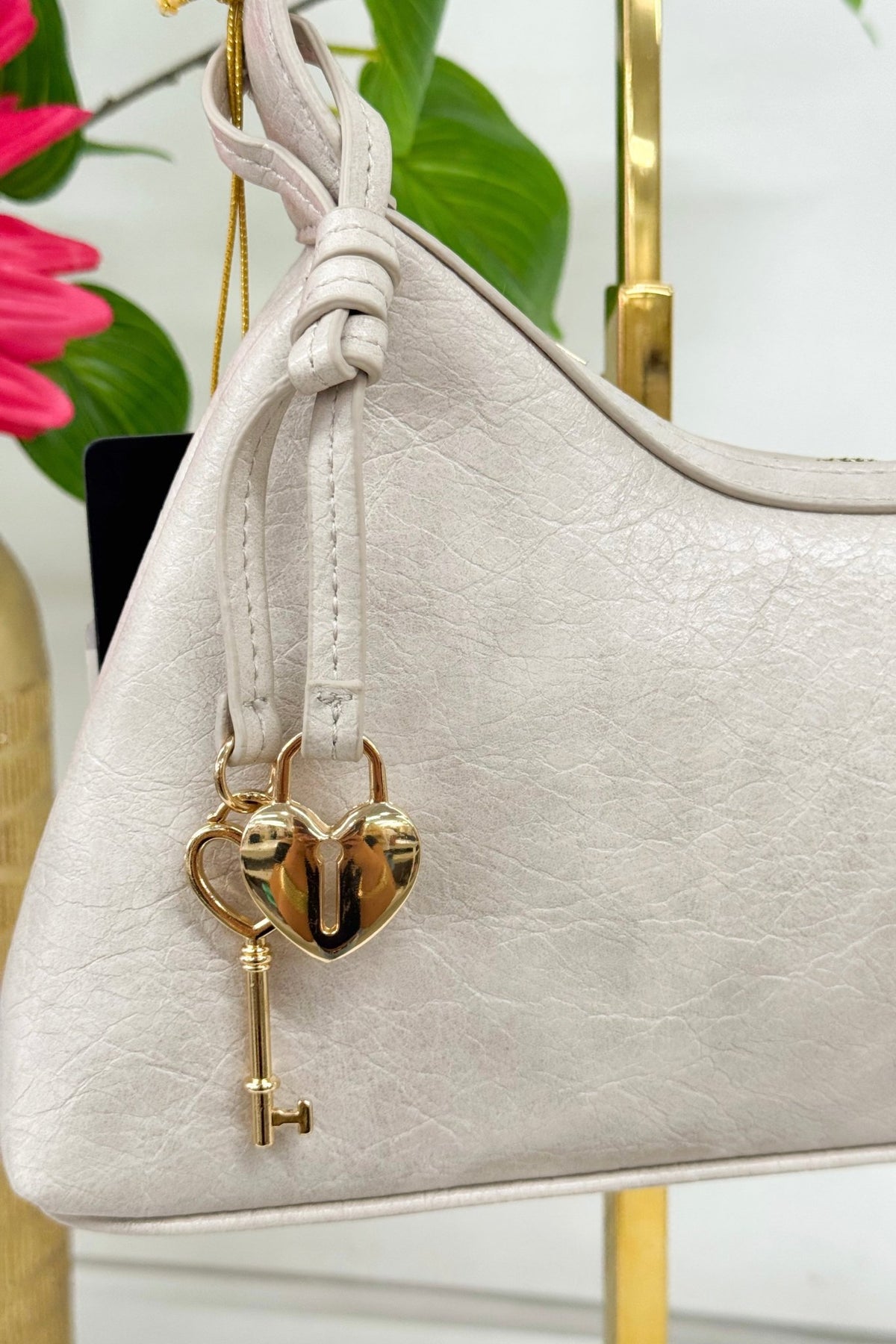 Heart locket detail on a cement grey shoulder bag