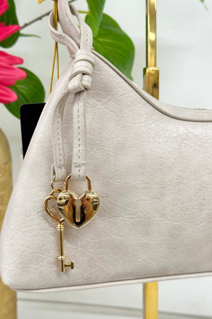 Heart locket detail on a cement grey shoulder bag