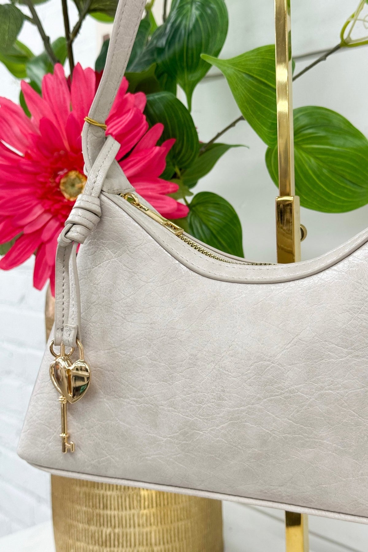 Cement shoulder purse with a heart-shaped hardware accent