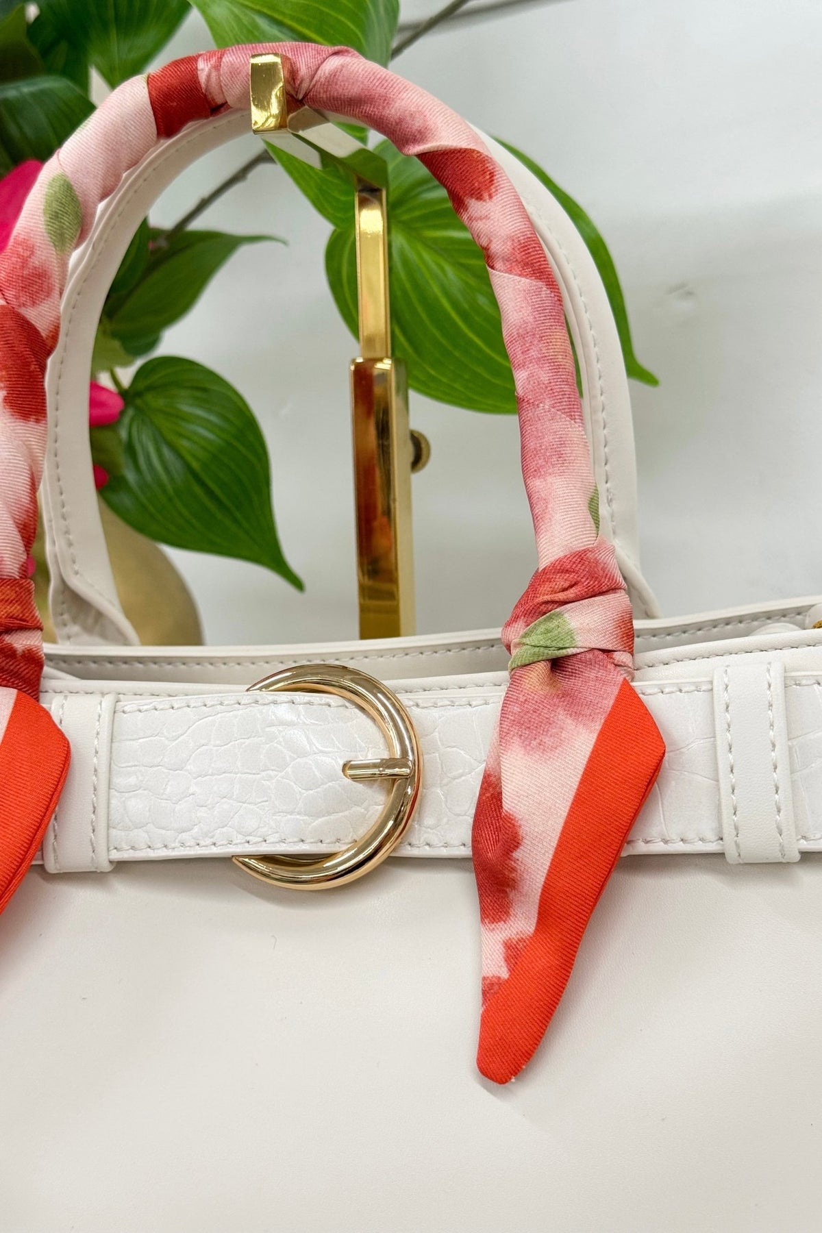 Small white handbag with a decorative scarf accent