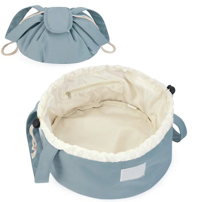 Grey-blue barrel makeup bag with drawstring closure, handles, and cream-lined interior