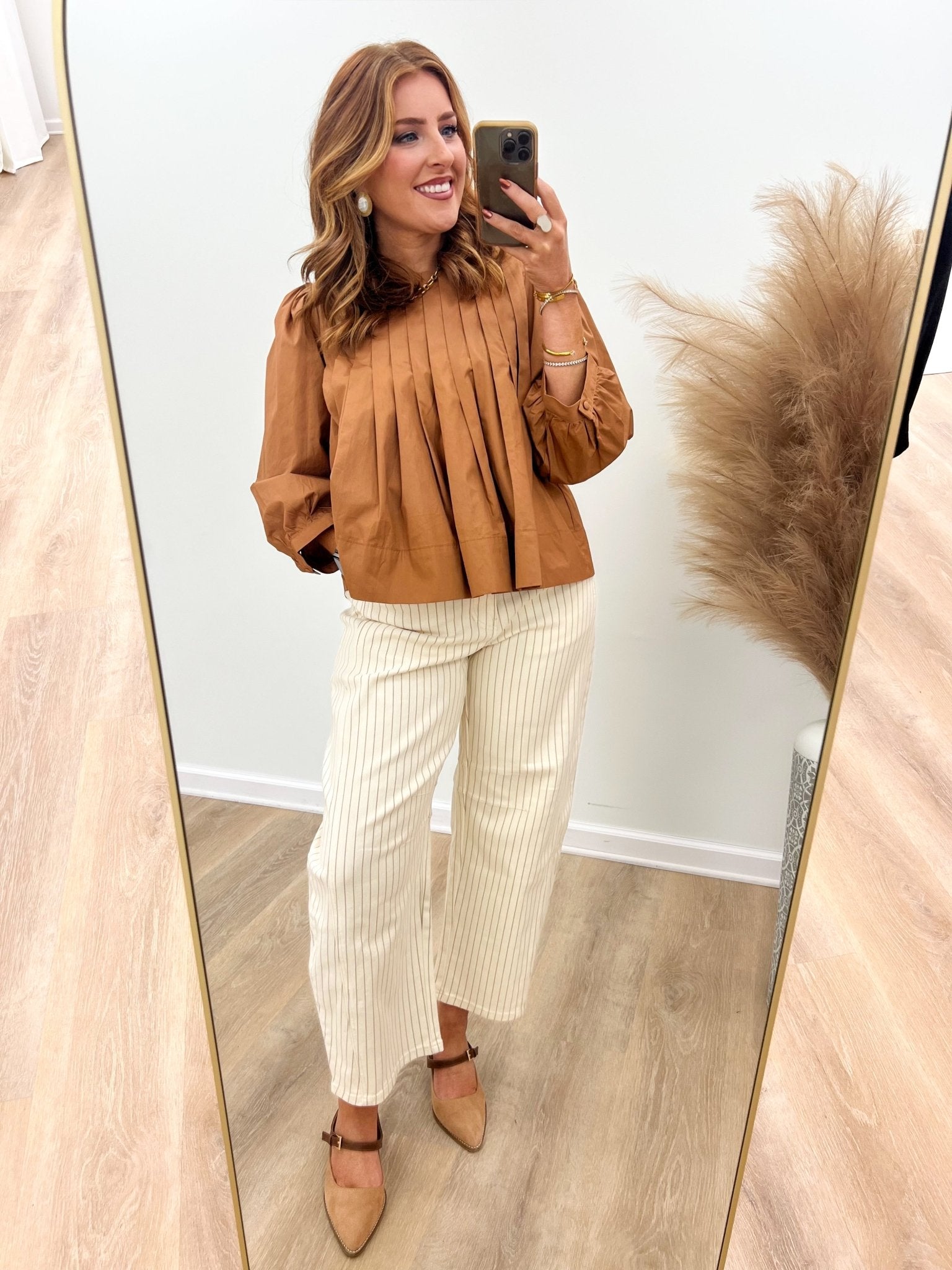 Cream pinstripe pants with a rounded barrel silhouette