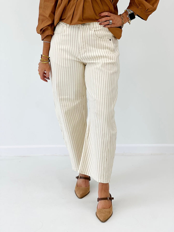 Cream pinstripe pants with a barrel leg shape