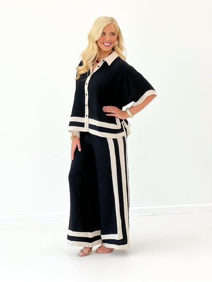 Black wide-leg pant set with short-sleeve button shirt and vertical stripe panels