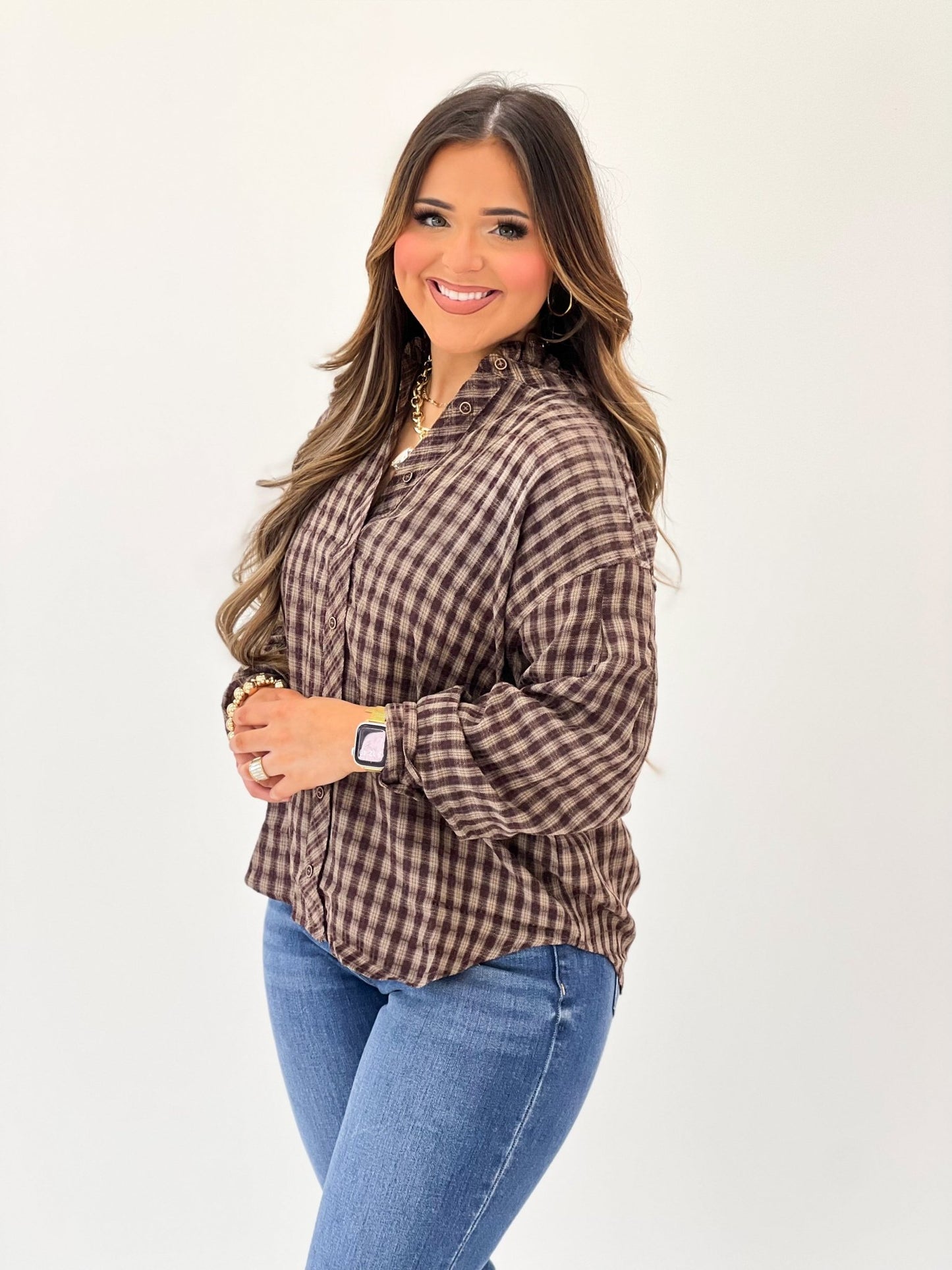 Brown checked blouse with gathered ruffle trim at the neck
