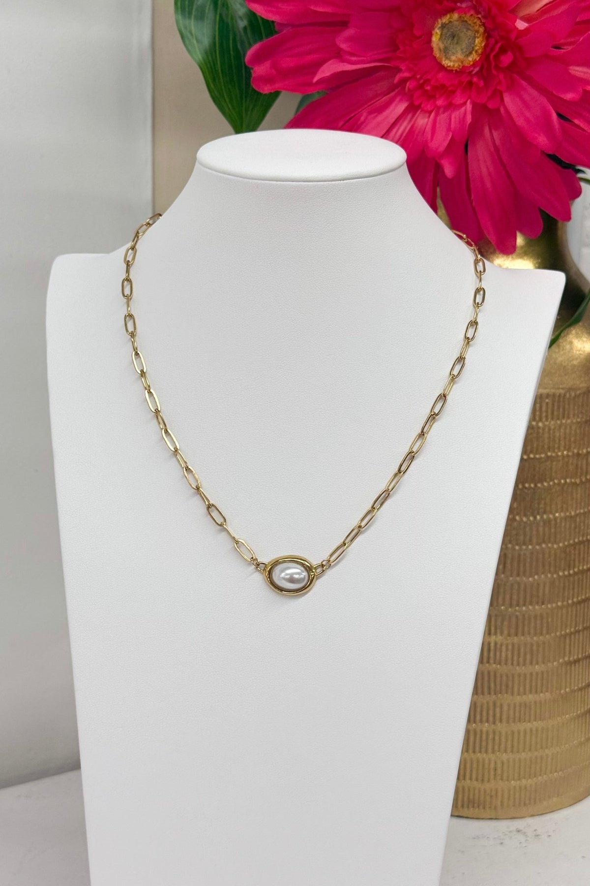 Oval pearls linked along a gold paperclip chain
