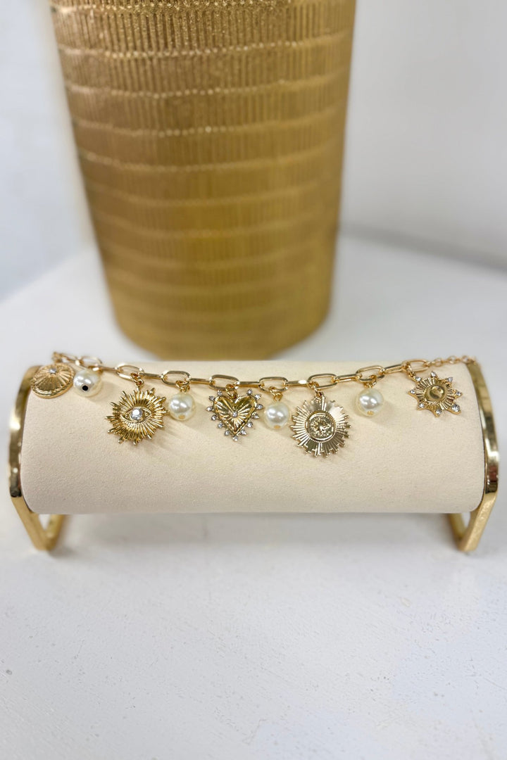 Cream pearl charm bracelet with gold sunburst charms