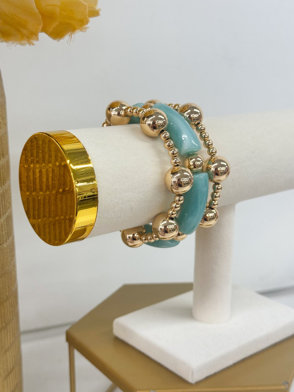 Stretch bracelet of tube beads and gold-tone rounds