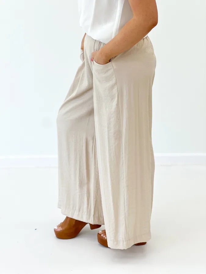 Tan pleated wide leg trousers with a high waist