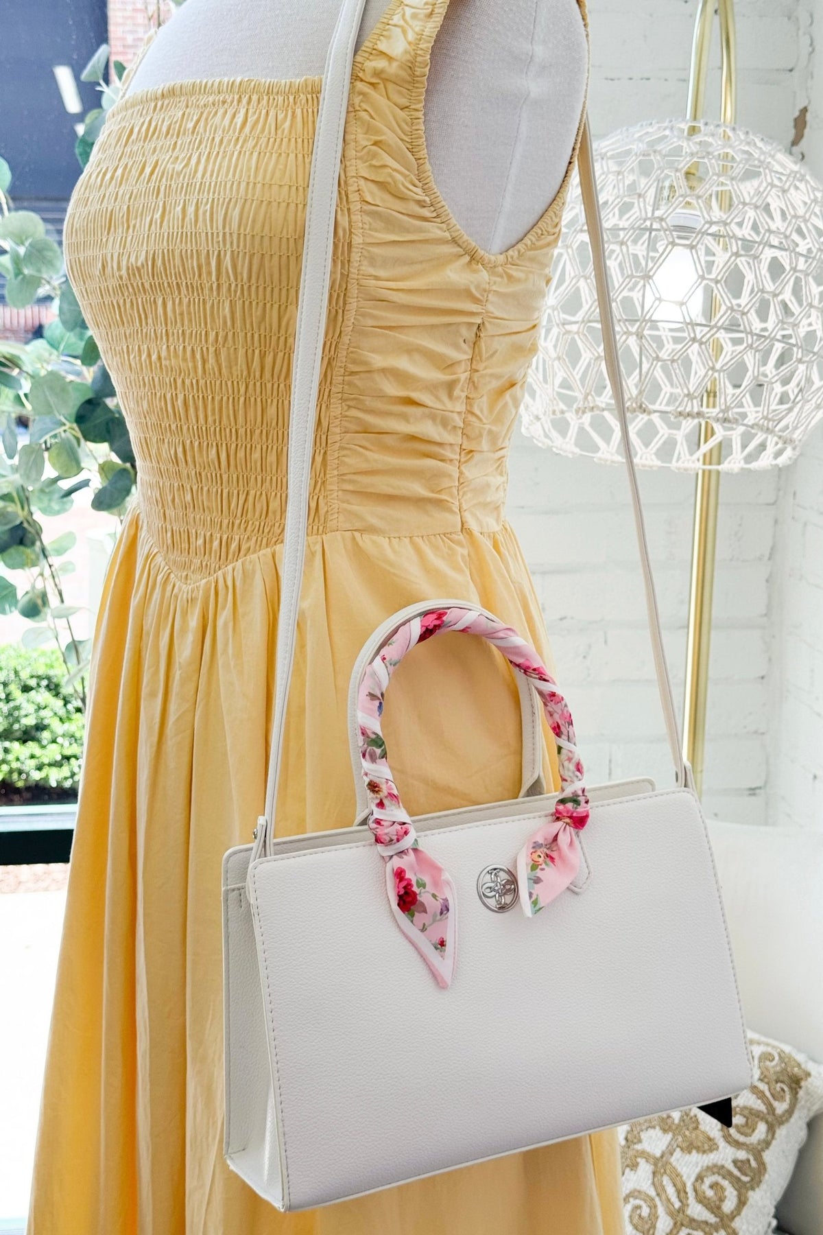 White crossbody purse with a decorative scarf accent