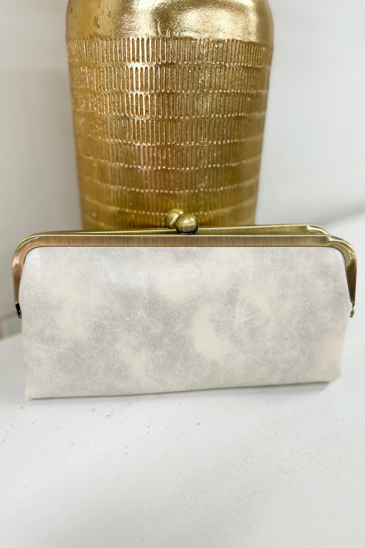 Pearl white kiss-lock clutch with top frame and small clasp detail