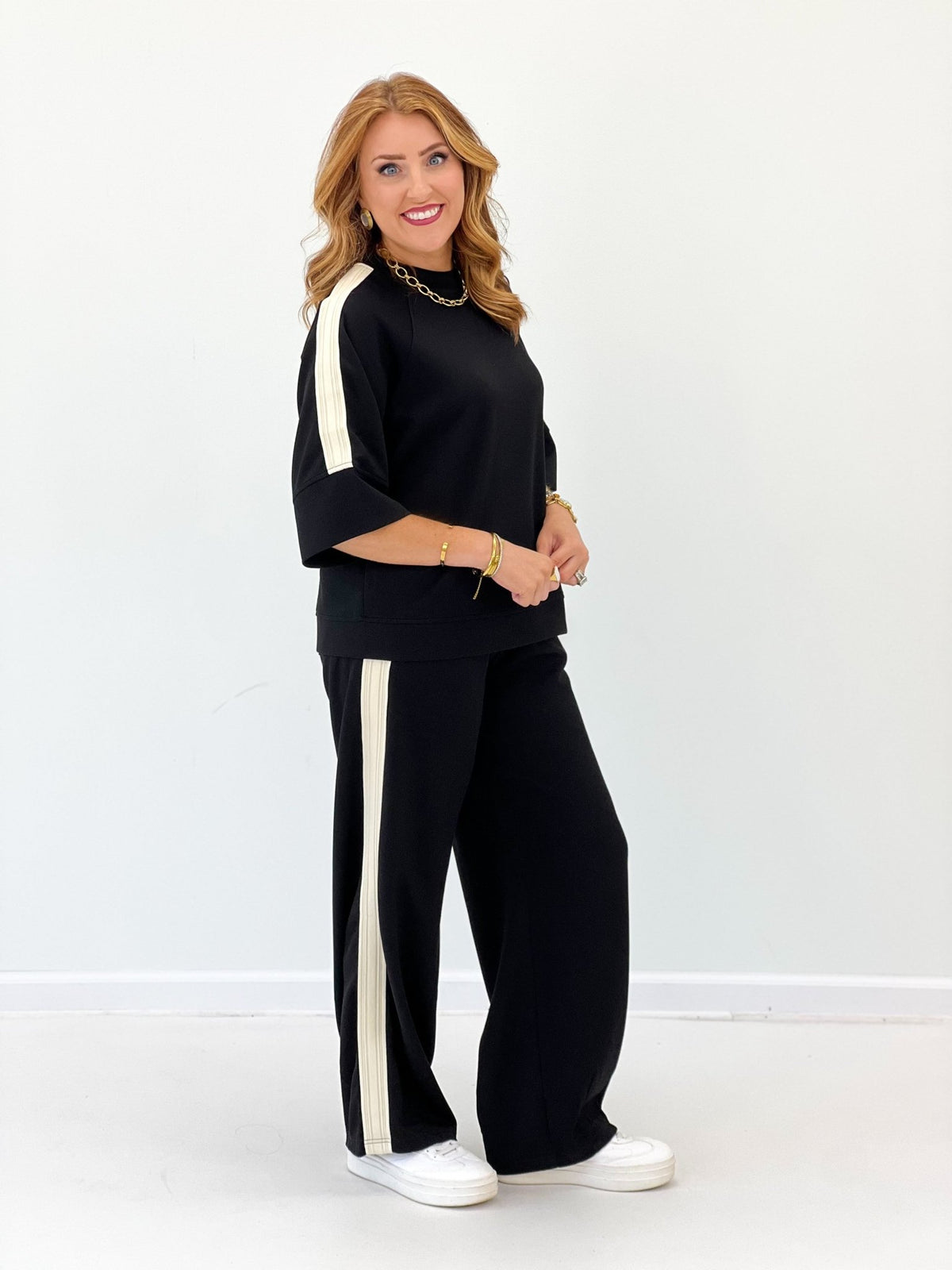 Black scuba-knit pant set with long-sleeve loose top and wide-leg pants, side stripe trim