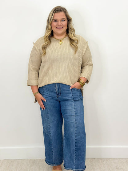Taupe knit top with 3/4 folded sleeves and round neckline, ribbed knit body