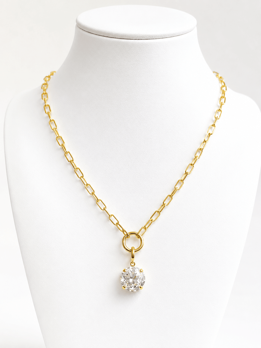 Faceted stone drop suspended from a gold chain