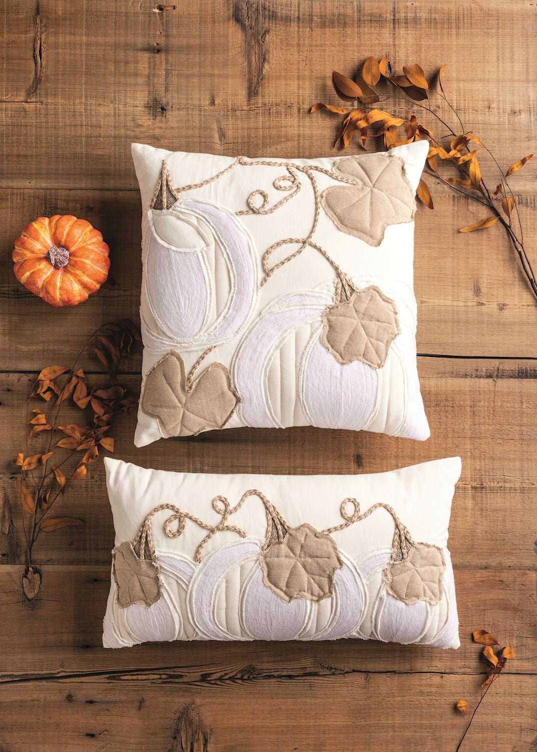 Appliqued pumpkin on a square cream and tan throw pillow