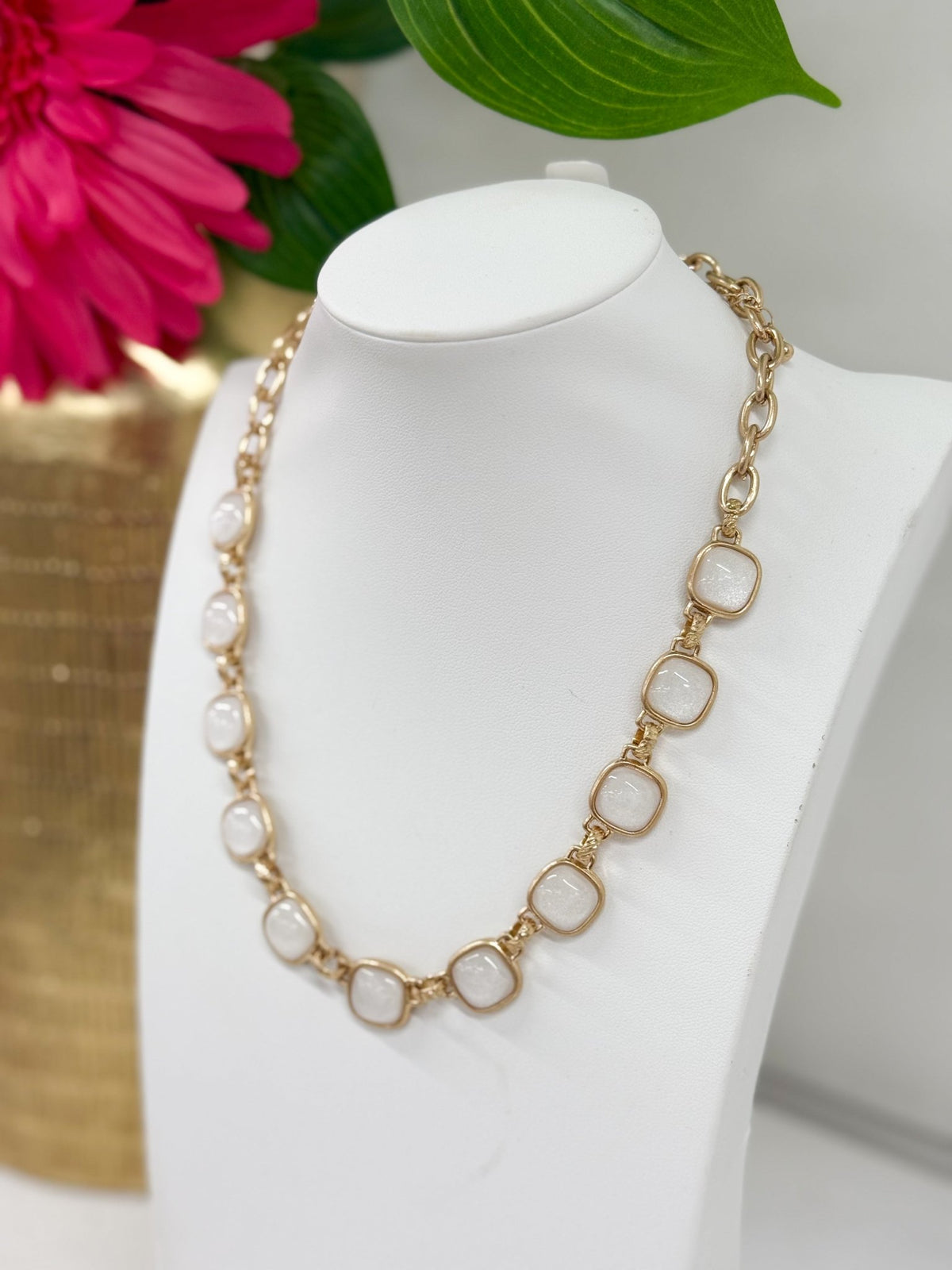 Square epoxy stone set in a gold-tone necklace